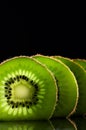 Cut slices of kiwi fruit close-up on black background vertical. Royalty Free Stock Photo