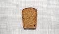 A cut square piece of black bread on a white background Royalty Free Stock Photo