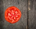 Cut tomato red with seeds and patterns. View from above. Black stone slate background. Royalty Free Stock Photo