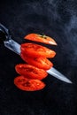 Cut the tomato into two halves with a sharp knife, splashes of water and juice fly in different directions. Levitation Royalty Free Stock Photo