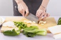 Cut vegetables on a wooden chopping board with both hands Royalty Free Stock Photo