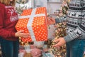 Cut view of woman holds red box with present. It has white ribbon aorund it. Man is going to take it. He reaches to Royalty Free Stock Photo