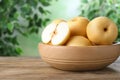 Cut and whole apple pears in bowl on wooden table against blurred background Royalty Free Stock Photo