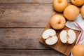 Cut and whole apple pears on wooden table, flat lay. Space for text