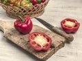 Cut and whole bell peppers on a cutting board on a wooden table Royalty Free Stock Photo