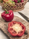 Cut and whole bell peppers on a cutting board on a wooden table Royalty Free Stock Photo