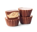 Cut and whole delicious peanut butter cups on white background