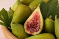 Cut and whole fresh green figs in wooden bowl, closeup Royalty Free Stock Photo