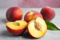 Cut and whole juicy peaches and leaves on table Royalty Free Stock Photo