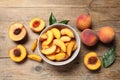 Cut and whole juicy peaches on wooden table, flat lay Royalty Free Stock Photo