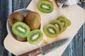 Cut and whole kiwi on a cutting Board and in a dish, wooden background Royalty Free Stock Photo