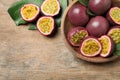 Cut and whole passion fruits maracuyas on wooden table, flat lay. Space for text Royalty Free Stock Photo