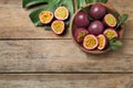 Cut and whole passion fruits maracuyas on wooden table, flat lay. Space for text Royalty Free Stock Photo