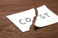 Cut the word cost concept for recession or credit crisis on wood.