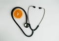 Cutaway orange and stethoscope on a white background