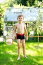 Cute active kid boy jumping in the garden on warm sunny summer day. Happy kid looking at the camera. Adorable child with Royalty Free Stock Photo