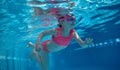 Cute, active, little baby girl, toddler in pink swimsuit diving, swimming underwater in swimming pool. Water sports Royalty Free Stock Photo