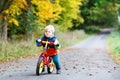Cute active little boy driving on his bike in autumn forest Royalty Free Stock Photo