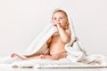 Cute, adorable baby, child in calmly sitting in towel against white studio background. After shower Royalty Free Stock Photo