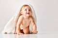 Cute, adorable baby, child in calmly sitting in towel against white studio background. After shower Royalty Free Stock Photo