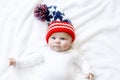 Cute adorable baby child with Christmas winter cap on white background. Happy baby girl or boy smiling and looking at Royalty Free Stock Photo