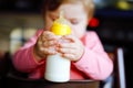 Cute adorable baby girl holding nursing bottle and drinking formula milk. First food for babies. New born child, sitting Royalty Free Stock Photo