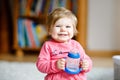 Cute adorable baby girl holding nursing bottle and drinking formula milk or water. First food for babies. Healthy babies Royalty Free Stock Photo