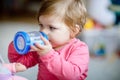 Cute adorable baby girl holding nursing bottle and drinking formula milk or water. First food for babies. Healthy babies Royalty Free Stock Photo