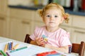 Cute adorable baby girl learning painting with pencils. Little toddler child drawing at home, using colorful felt tip Royalty Free Stock Photo