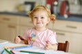 Cute adorable baby girl learning painting with pencils. Little toddler child drawing at home, using colorful felt tip Royalty Free Stock Photo