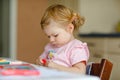 Cute adorable baby girl learning painting with pencils. Little toddler child drawing at home, using colorful felt tip Royalty Free Stock Photo