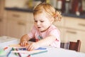 Cute adorable baby girl learning painting with pencils. Little toddler child drawing at home, using colorful felt tip Royalty Free Stock Photo