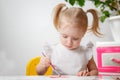 Cute adorable baby girl learning painting with water colors. Little toddler child drawing at home, using colorful brushes. Healthy Royalty Free Stock Photo