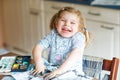 Cute adorable baby girl learning painting with water colors. Little toddler drawing at home, using colorful brushes Royalty Free Stock Photo