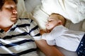 Cute adorable baby girl of 6 months and her father sleeping peaceful in bed at home Royalty Free Stock Photo