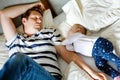 Cute adorable baby girl of 6 months and her father sleeping peaceful in bed at home Royalty Free Stock Photo