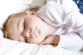 Cute adorable baby girl of 6 months sleeping peaceful in bed