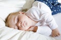 Cute adorable baby girl of 6 months sleeping peaceful in bed Royalty Free Stock Photo