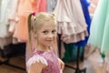 Cute adorable beautiful blond caucasian little girl trying on fashion pink princess dress with sequins at children Royalty Free Stock Photo