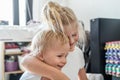 Cute adorable blond caucaian little sister hugging her toddler brother.couple of cheerful sibling playing indoor. Cute girl and Royalty Free Stock Photo