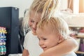 Cute adorable blond caucaian little sister hugging her toddler brother.couple of cheerful sibling playing indoor. Cute Royalty Free Stock Photo