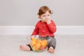Cute adorable Caucasian baby boy eating citrus fruit mandarine orange. Finny child eating healthy organic snack tangerine. Solid