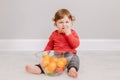 Cute adorable Caucasian baby boy eating citrus fruit tangerine orange. Finny child eating healthy organic snack tangerine. Solid