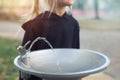 Cute adorable caucasian blond little thirsty school girl drinking water from public potable fountain faucet in city park