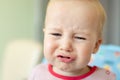 Cute adorable caucasian blond toddler boy sitting in high chair and crying while feeding. Upset unhappy child refuse to eat Royalty Free Stock Photo