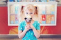 Caucasian blonde preschool girl child with blue eyes holding ice cream in large waffle cone Royalty Free Stock Photo