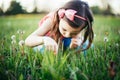 Cute adorable Caucasian girl picking flowers dandelions. Kid sitting in grass on meadow. Outdoors fun summer seasonal children Royalty Free Stock Photo