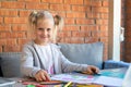 Cute adorable caucasian little blond kid girl enjoy painting with colorful crayons and paper sketchbook at yard table Royalty Free Stock Photo