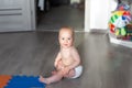 Cute adorable caucasian little infant baby boy enjoy playing in room sitting on floor with toys and soft mats on sunny day. Funny Royalty Free Stock Photo