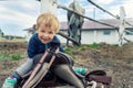 Cute adorable caucasian little smiling toddler portrait boy sitting on saddle on ground enjoy having fun riding supposed Royalty Free Stock Photo